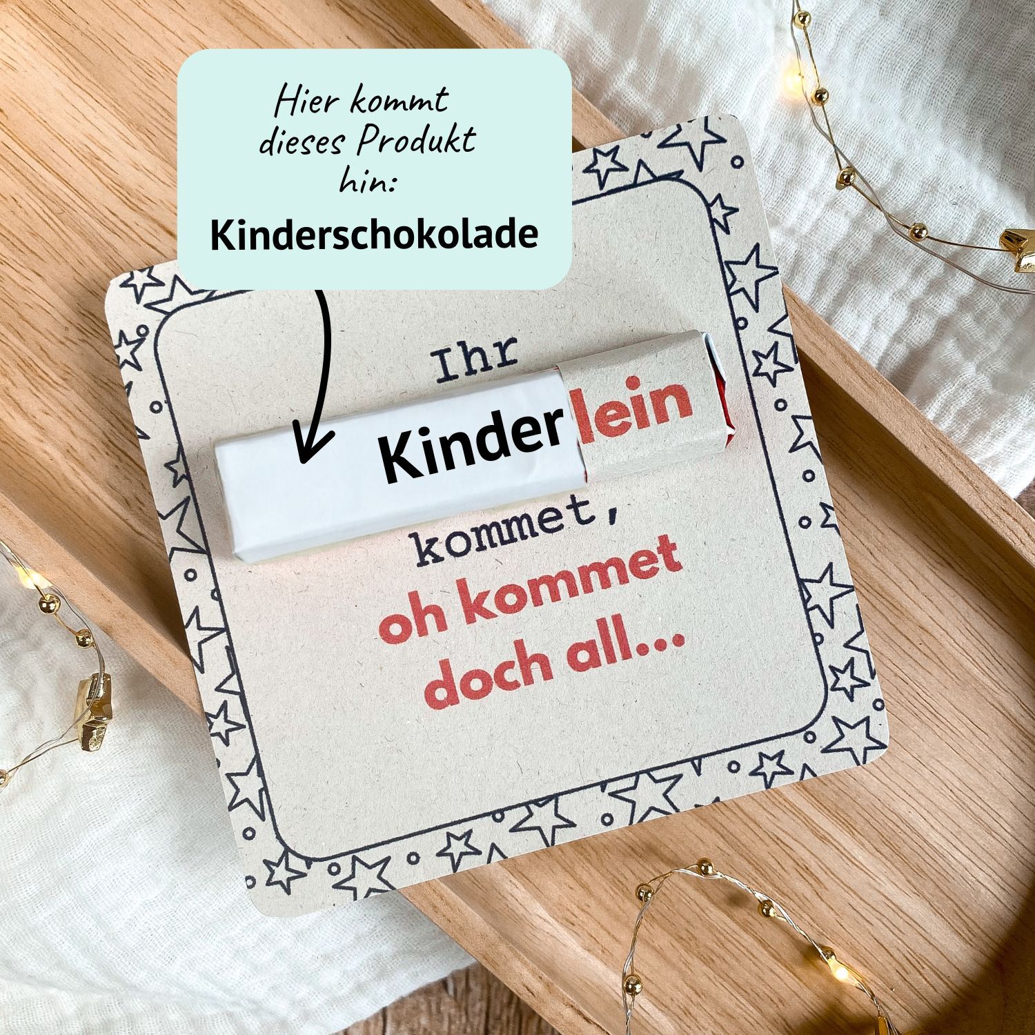 Lustiges Wichtelgeschenk mit Kinderschokolade Riegel – weihnachtliche Druckvorlage Kreative Weihnachts-Druckvorlage mit dem Spruch „Ihr Kinderlein kommet, oh kommet doch all…“. In die Karte wird eine Kinderschokolade gesteckt. Liebevoll fotografiert auf Holztablett mit Lichterkette – ideale Idee für ein kleines Wichtelgeschenk zu Weihnachten.